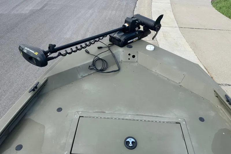 Slide: The Image of 2024 Tracker Grizzly 1648 SC boat with Minn Kota trolling motor on deck. - 29