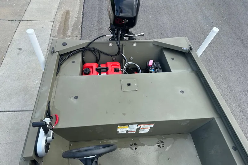 Slide: The Image of 2024 Tracker Grizzly 1648 SC boat interior with steering wheel and engine components. - 32