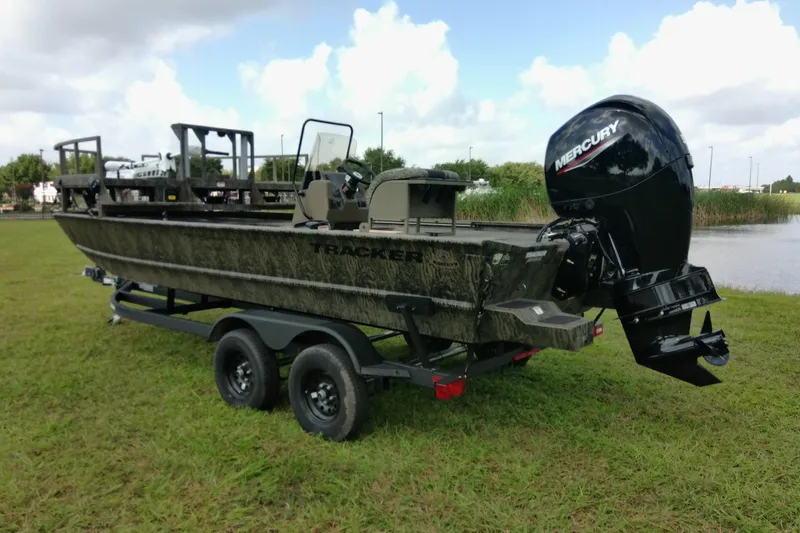 Slide: The Image of 2026 Tracker Grizzly 2072 CC Sportsman boat with Mercury engine on trailer, parked on grass. - 78