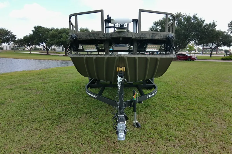 Slide: The Image of 2026 Tracker Grizzly 2072 CC Sportsman boat on trailer, parked on grass near a pond. - 75