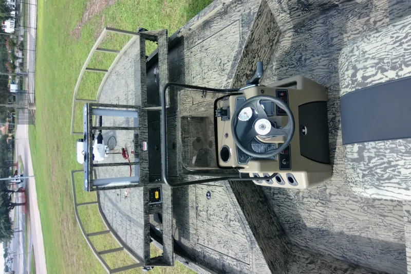 Slide: The Image of 2026 Tracker Grizzly 2072 CC Sportsman boat interior with steering console and camouflage design. - 84
