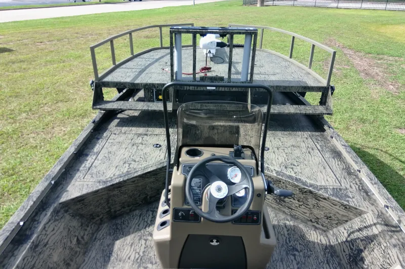 Slide: The Image of 2026 Tracker Grizzly 2072 CC Sportsman boat with steering console on grassy area. - 83