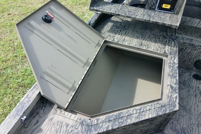 Slide: The Image of Open storage compartment on 2026 Tracker Grizzly 2072 CC Sportsman boat, featuring camo design. - 87