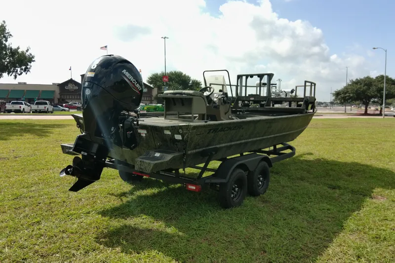 Slide: The Image of 2026 Tracker Grizzly 2072 CC Sportsman boat on trailer, parked on grass under cloudy sky. - 80