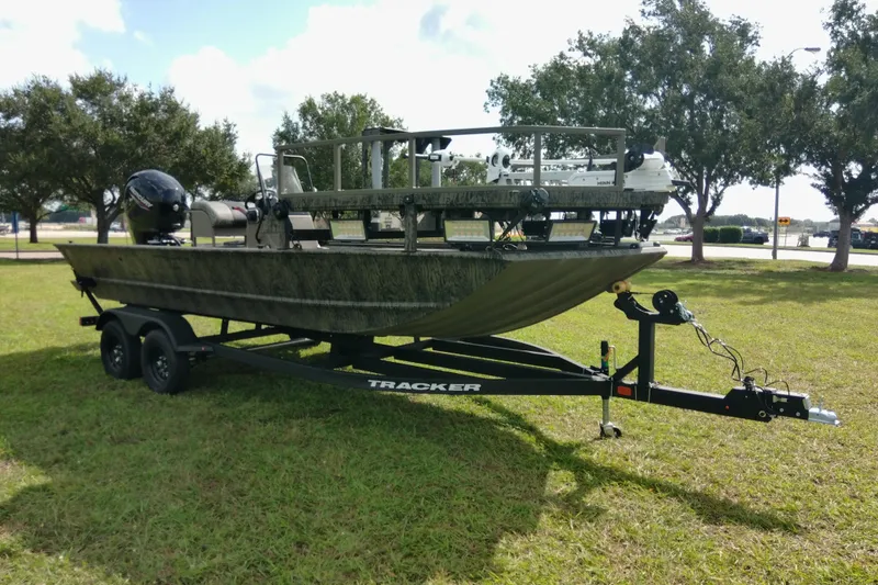 Slide: The Image of 2026 Tracker Grizzly 2072 CC Sportsman boat on trailer, parked on grass. - 82
