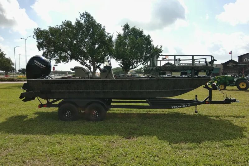 Slide: The Image of 2026 Tracker Grizzly 2072 CC Sportsman boat on trailer, parked on grass. - 81