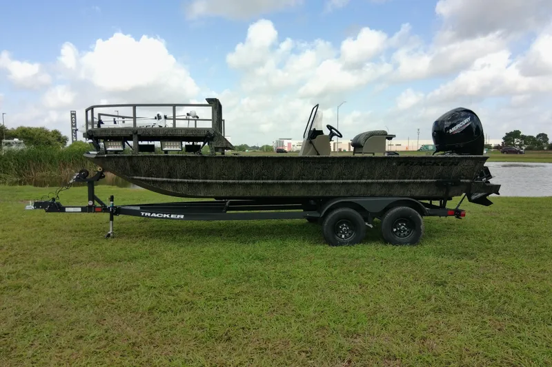 Slide: The Image of 2026 Tracker Grizzly 2072 CC Sportsman boat on trailer, parked on grassy field. - 77