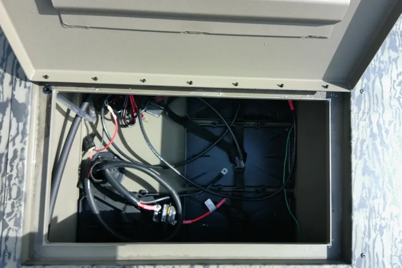 Slide: The Image of Open compartment of 2026 Tracker Grizzly 2072 CC Sportsman showing wiring and components. - 13