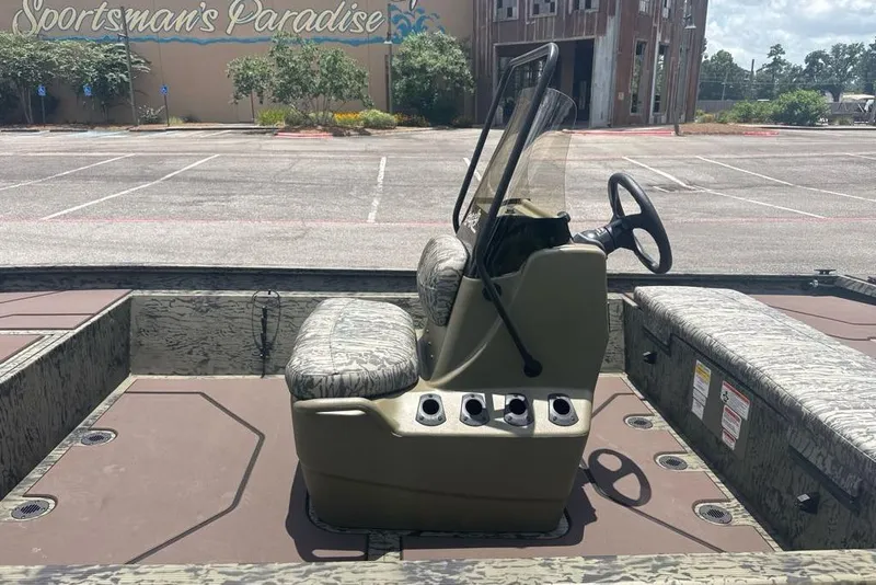 Slide: The Image of 2026 Tracker Grizzly 1860 CC boat interior with camouflage seating, parked at Sportsman's Paradise. - 5