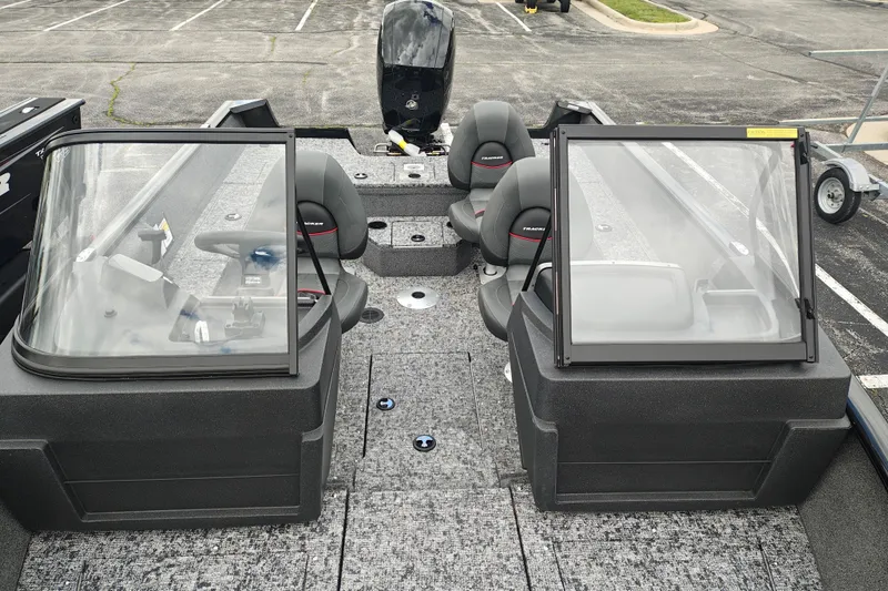 Slide: The Image of 2026 Tracker Pro Guide V-175 WT boat interior with seating and windshield in a parking lot. - 14