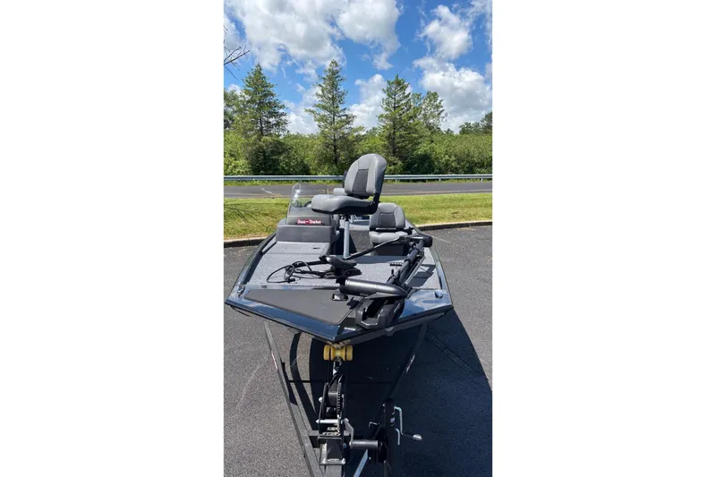 Slide: The Image of 2026 Tracker Bass Tracker Classic XL boat on pavement, surrounded by trees and blue sky. - 3