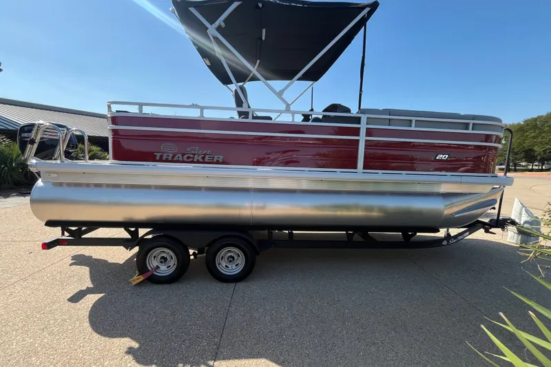 The Image of 2026 Sun Tracker SportFish 20 DLX pontoon boat on trailer, side view. - 0