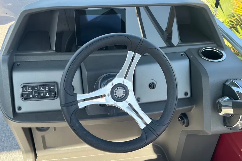 Slide: The Image of 2026 Sun Tracker SportFish 20 DLX dashboard with steering wheel and control panel. - 15