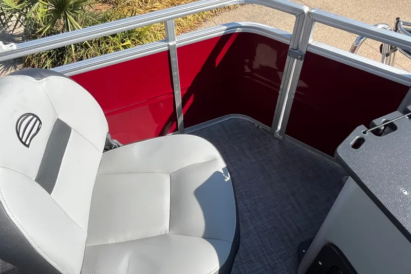 Slide: The Image of 2026 Sun Tracker SportFish 20 DLX boat interior with gray seating and red paneling. - 17
