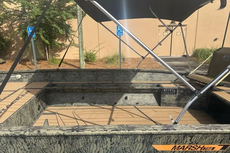 Slide: The Image of 2026 Tracker Grizzly 1756 T Marsh boat with camouflage design and canopy, parked outdoors. - 6