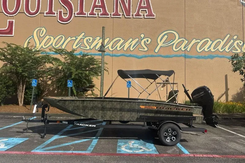 The Image of 2026 Tracker Grizzly 1756 T Marsh boat parked in front of "Sportsman's Paradise" mural. - 0