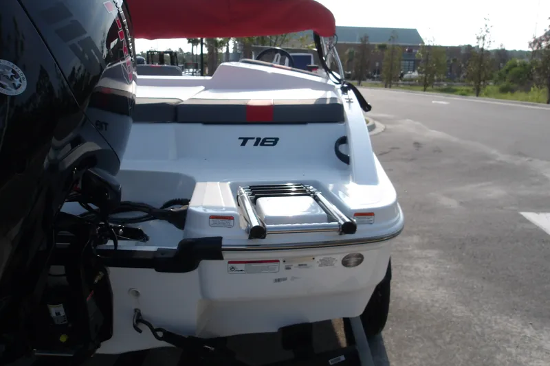 Slide: The Image of 2026 Tahoe T18 boat rear view with ladder and outboard motor in parking lot. - 10