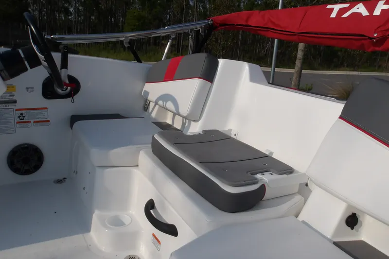 Slide: The Image of Interior of 2026 Tahoe T18 boat with gray and red seating, steering wheel, and storage compartments. - 14
