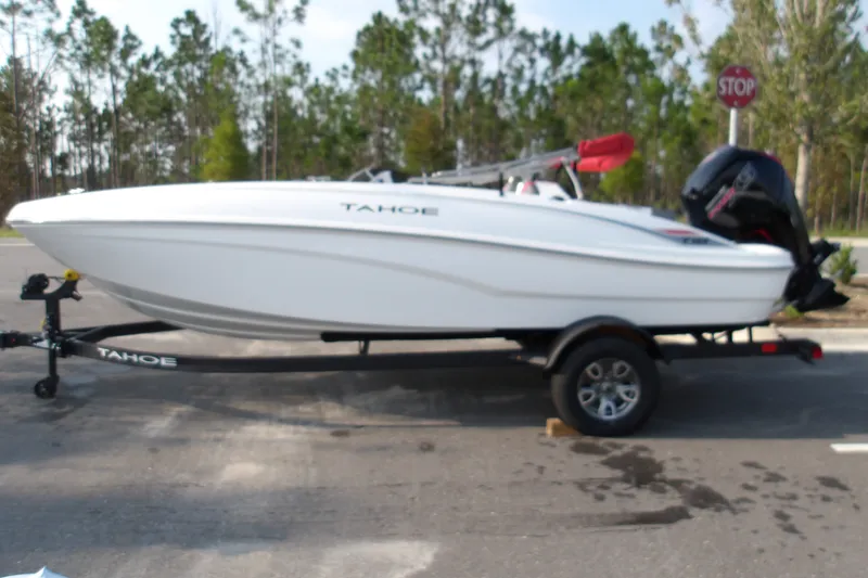 The Image of 2026 Tahoe T18 boat on trailer, parked outdoors with trees in background. - 1