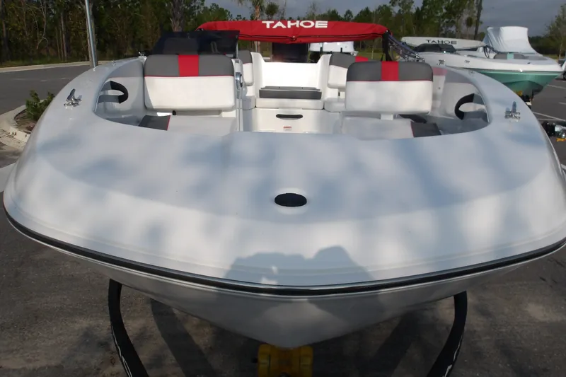Slide: The Image of 2026 Tahoe T18 boat with sleek white design and red accents, parked outdoors. - 18