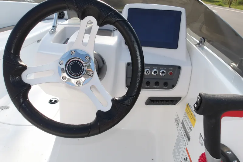 Slide: The Image of Steering wheel and dashboard of 2026 Tahoe T18 boat, featuring control panel and display screen. - 9