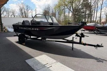 Slide: The Image of 2026 Tracker Pro Guide V-16 WT boat on trailer, parked outdoors. - 2