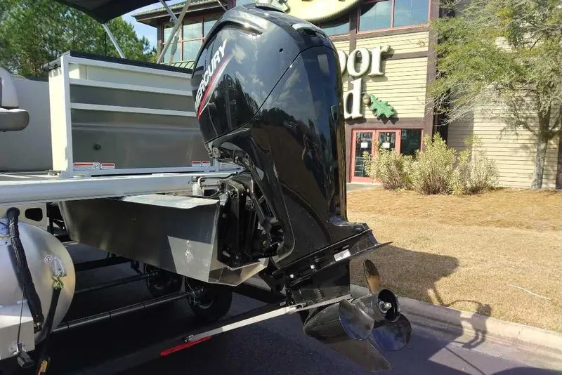 Slide: The Image of 2026 Sun Tracker Fishin' Barge 20 DLX with Mercury outboard motor, parked outdoors. - 12
