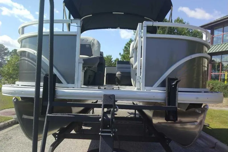 Slide: The Image of 2026 Sun Tracker Fishin' Barge 20 DLX pontoon boat on trailer, sunny day. - 6