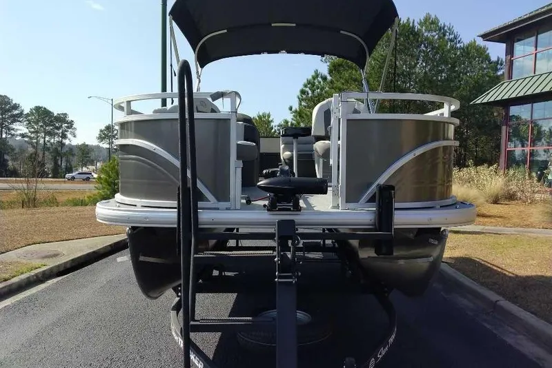 Slide: The Image of 2026 Sun Tracker Fishin' Barge 20 DLX pontoon boat parked outdoors. - 9