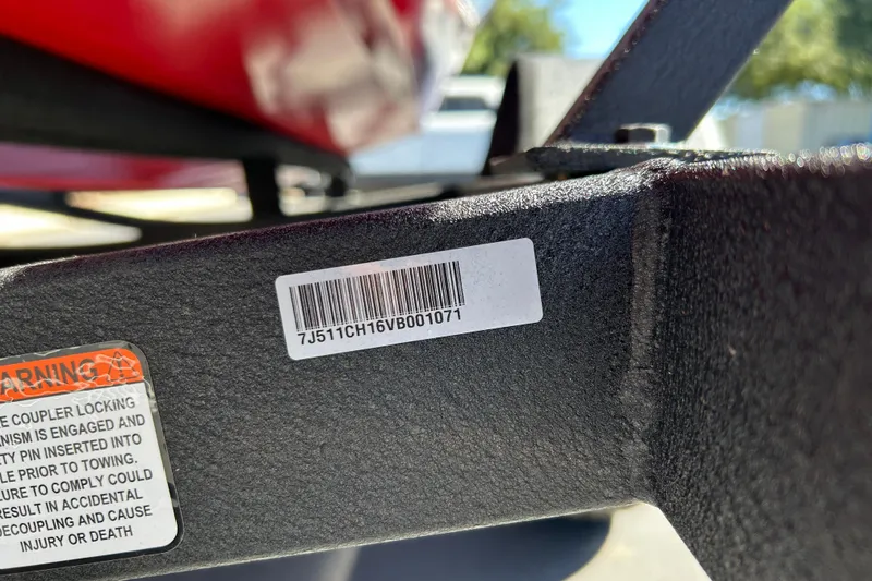 Slide: The Image of Close-up of a 2026 Tracker Pro Team 175 Crappie Edition trailer with barcode and warning label. - 70