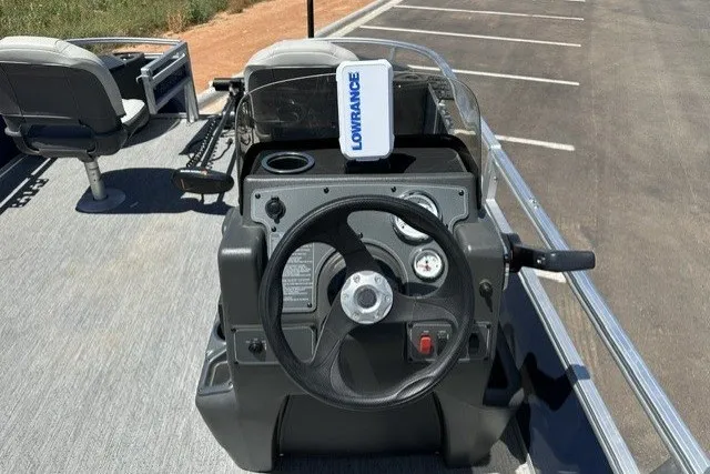 Slide: The Image of 2026 Sun Tracker Bass Buggy 18 DLX boat dashboard with steering wheel and Lowrance device. - 19