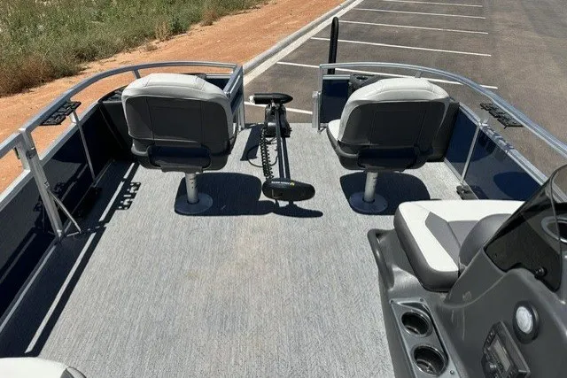 Slide: The Image of 2026 Sun Tracker Bass Buggy 18 DLX pontoon boat interior with seating and steering console. - 17