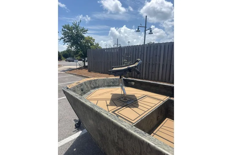 Slide: The Image of 2026 Tracker Grizzly 1650 T Prairie Wings Edition boat in parking lot under blue sky. - 3