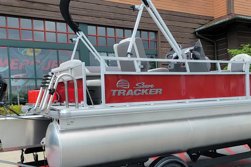 The Image of 2026 Sun Tracker Bass Buggy 16 XL Select pontoon boat, red exterior, parked outside. - 0