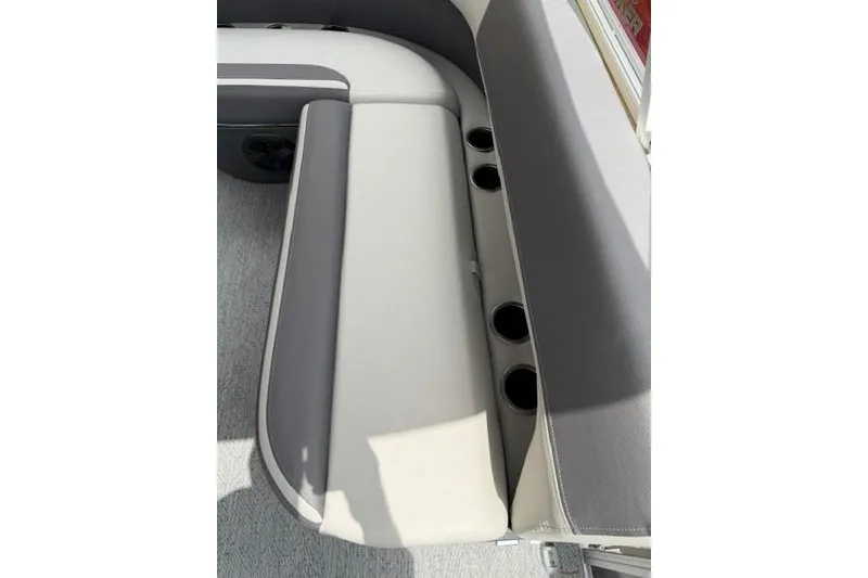 Slide: The Image of Sun Tracker Bass Buggy 16 XL Select 2026 boat seating with cup holders, featuring gray and white upholstery. - 13