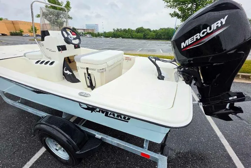 Slide: The Image of 2026 Mako Pro Skiff 15 CC boat with Mercury engine on trailer in parking lot. - 5
