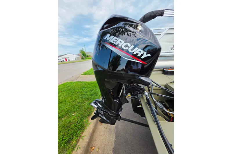Slide: The Image of 2026 Tracker Grizzly 1754 SC with Mercury outboard motor on a street. - 2