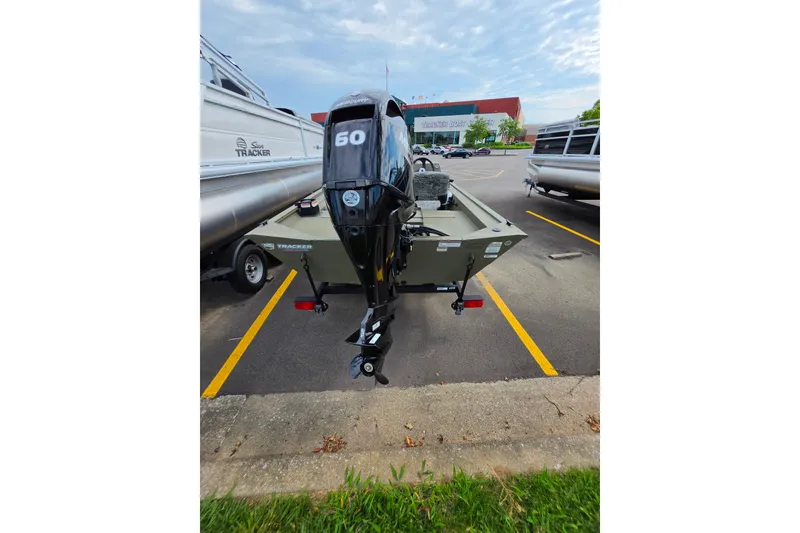 Slide: The Image of 2026 Tracker Grizzly 1754 SC boat with 60 HP motor in parking lot. - 4