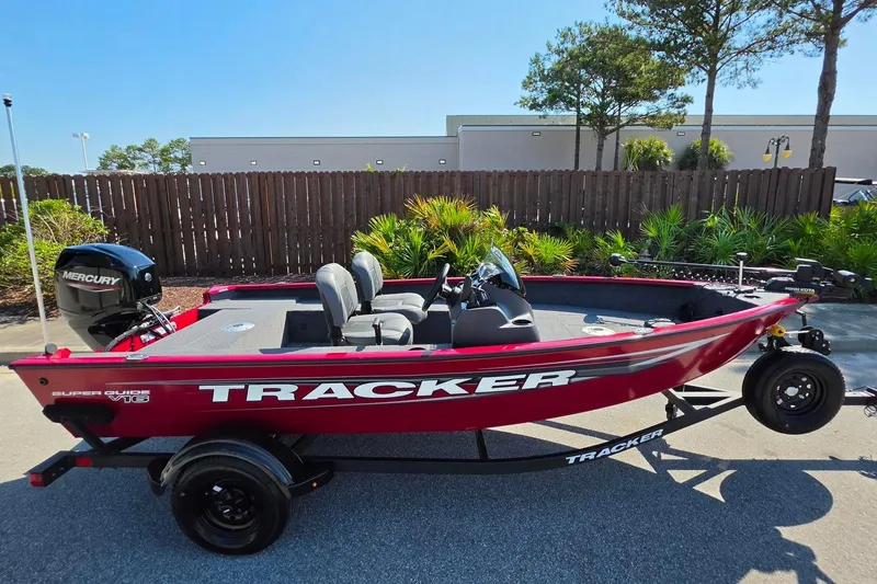Slide: The Image of 2026 Tracker Super Guide V-16 SC boat, red exterior, parked outdoors on a trailer. - 6