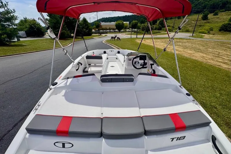 Slide: The Image of 2026 Tahoe T18 boat with red canopy, sleek design, parked on a scenic road. - 5