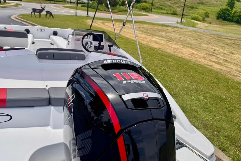 Slide: The Image of 2026 Tahoe T18 boat with Mercury 115 Pro engine, parked on grass near a road. - 10