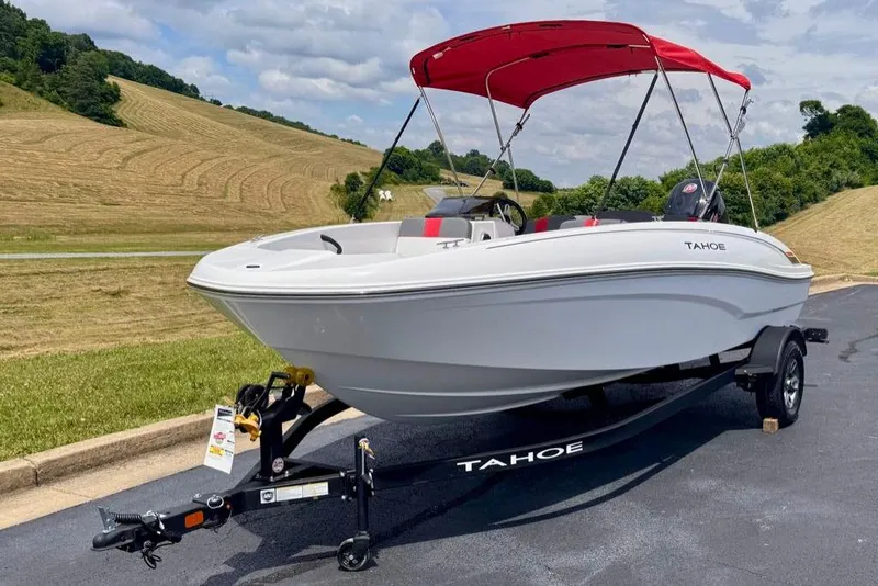 Slide: The Image of 2026 Tahoe T18 boat with red canopy on trailer, parked on scenic road. - 3