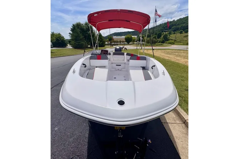 Slide: The Image of 2026 Tahoe T18 boat with red canopy, parked outdoors on a sunny day. - 4
