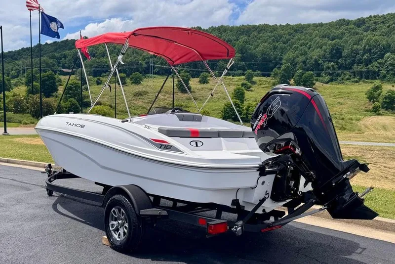Slide: The Image of 2026 Tahoe T18 boat with red canopy and powerful outboard motor on trailer. - 6