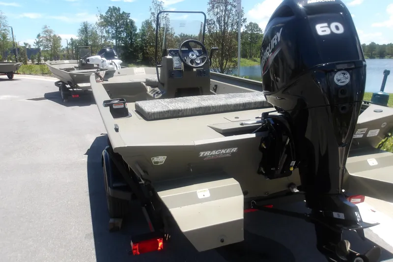 Slide: The Image of 2026 Tracker Grizzly 1860 CC boat with Mercury 60 engine, parked near a lake. - 3
