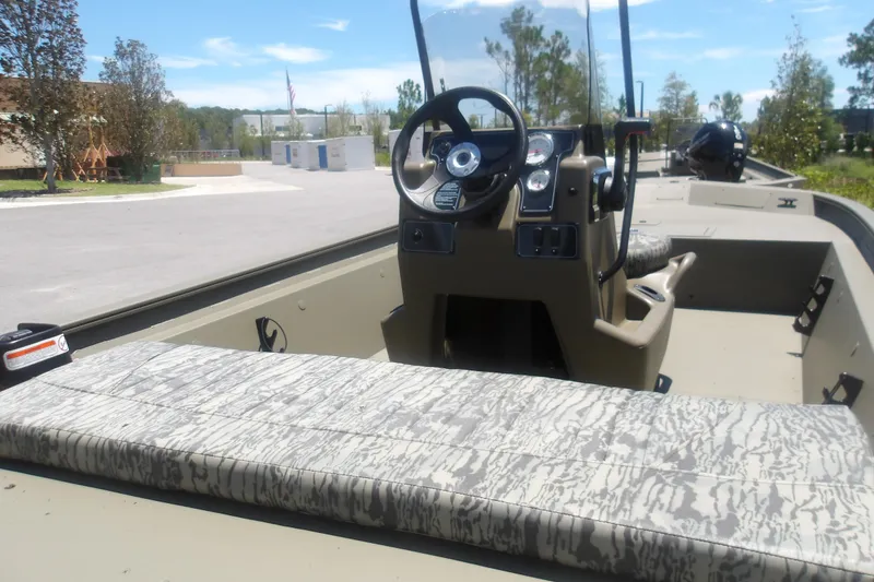 Slide: The Image of 2026 Tracker Grizzly 1860 CC boat interior with steering console and patterned seating. - 10