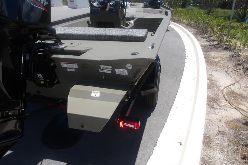 Slide: The Image of 2026 Tracker Grizzly 1860 CC boat on trailer, rear view, parked on roadside. - 4