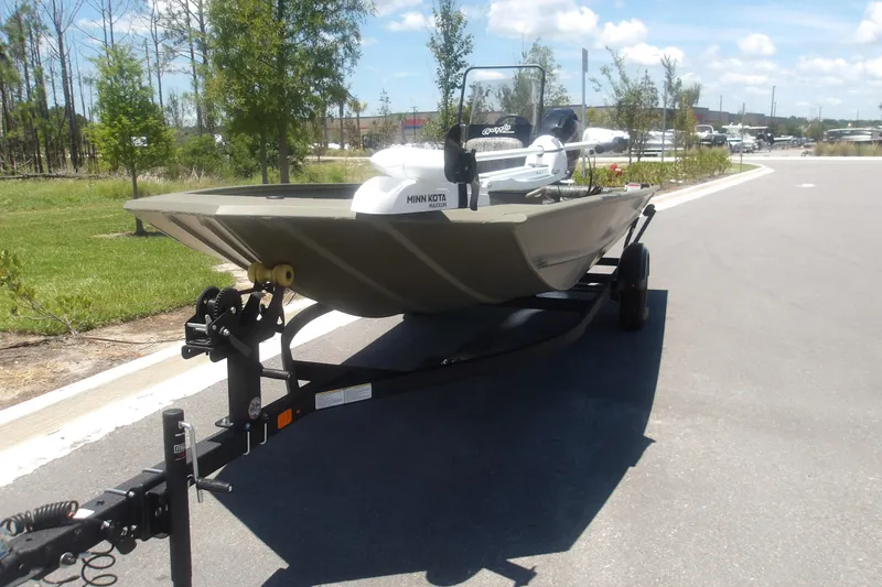 Slide: The Image of 2026 Tracker Grizzly 1860 CC boat on trailer, parked outdoors on a sunny day. - 5