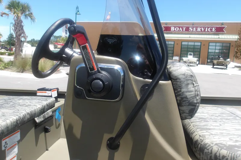 Slide: The Image of 2026 Tracker Grizzly 1860 CC boat interior with steering wheel and throttle control. - 9