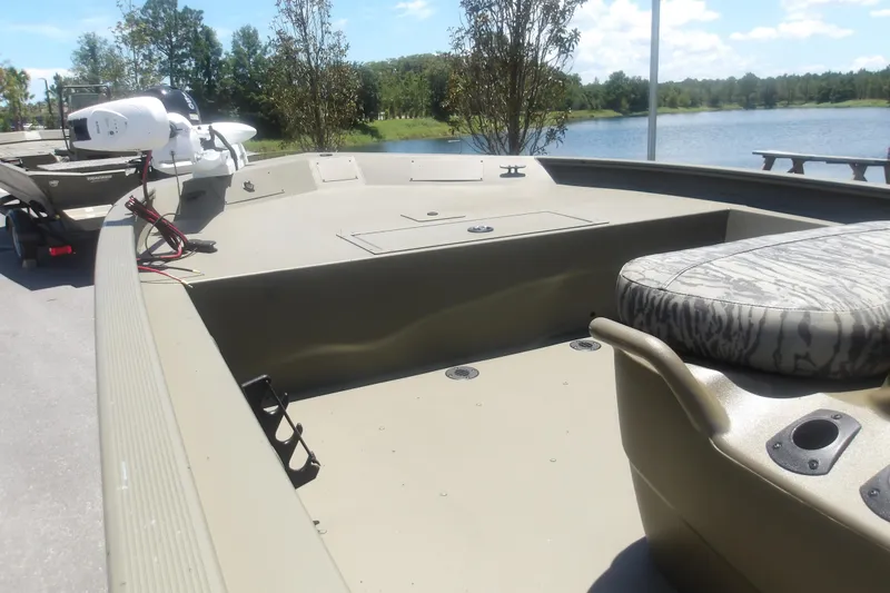 Slide: The Image of 2026 Tracker Grizzly 1860 CC boat with seating, near a serene lake. - 11